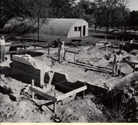 Black and White Photograph of Men Surveying the Dig