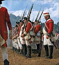 Reenactors portray the redcoats in their standard lines of battle: rows of infantrymen, bayonets fixed to muskets, who loaded and fired in quick order.