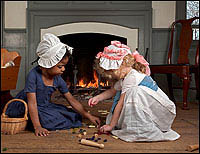 Alongside homemade ones, commercially produced toys became more common in the
eighteenth century, offering recreation and, betimes, social or moral
instruction to children. Maya Canaday, left, plays with Eleanor McCoy at the
Benjamin Powell House.