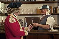 A bartender hands a drink to an officer