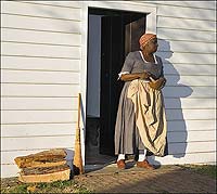 Valarie Grey-Holmes as Lydia Broadnax, George Wythe's cook, at the door of the Wythe kitchen.