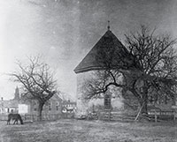 A horse grazing nearby and Bruton Parish Church’s tower in the background, the repaired Magazine early in the twentieth century.