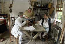 Inside, Thomas Hansford and John Drewry-;friends, fellow lodgers, tailor and carpenter-;rest from the business of the day with seamstress and laundress Elizabeth Maloney, in persons of Mark Hutter, left, Jennifer Belvin, and Jay Templin.