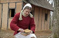 A woman cards wool