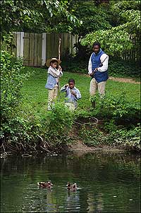 interpreter Robert Watson and twins DeVonte and DeAndre Short fish in a duck pond