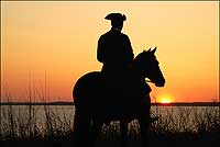 Richard Nicoll, director of coach and livestock, enjoys a James River sunset
with horse Pete.
