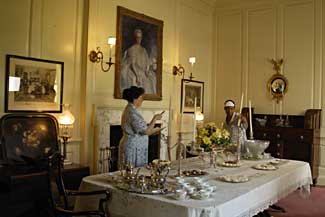 Preparing for a soirée in the ostentatiously Colonial Revival Carter’s Grove dining room, Mistress Molly McCrea, interpreted by Sandy Holsten, directs maid Edmonia Washington, portrayed by Jean Mitchell.