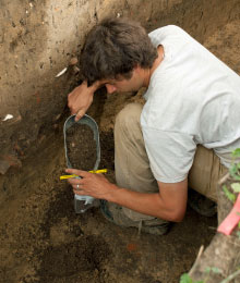 An archaeologist takes a sample from the dig.