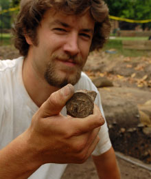 An archaeologist exhibits a bottle seal.
