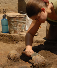 An archaeologist uncovers cannonballs.