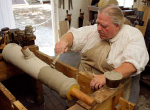 A founder coats a cannon mold.